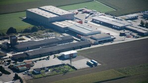 An industrial facility with large buildings, parking areas, and adjacent fields. - Nibelungenmotel (Poechlarn)