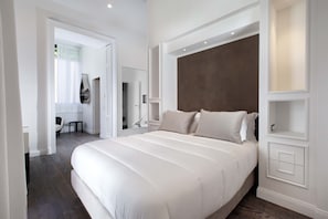 A modern bedroom with a large bed, built-in shelving, and a walk-in closet. - AMORE RENTALS - Diamond Home De Luxe - Luxury Apartment with Terrace in Central Sorrento (Sorrento)