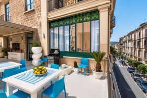 An outdoor seating area with a grill, tables, chairs, and potted plants. - AMORE RENTALS - Diamond Home De Luxe - Luxury Apartment with Terrace in Central Sorrento (Sorrento)