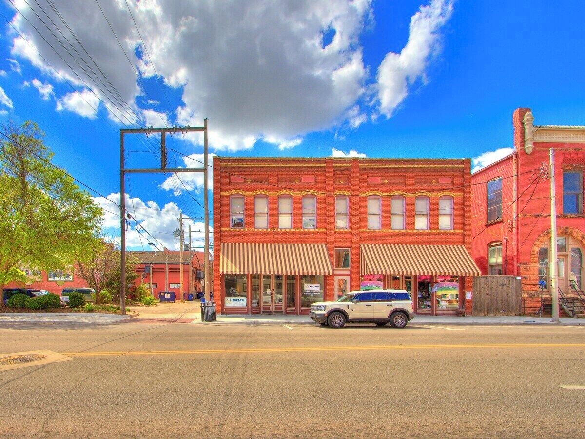 A red brick building with a white car parked in front.
