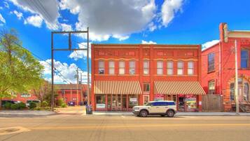 A red brick building with a white car parked in front.