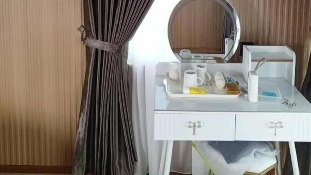 A hotel room with a white vanity, a round mirror, and a window with curtains. - Borneo blue ocean (Semporna)
