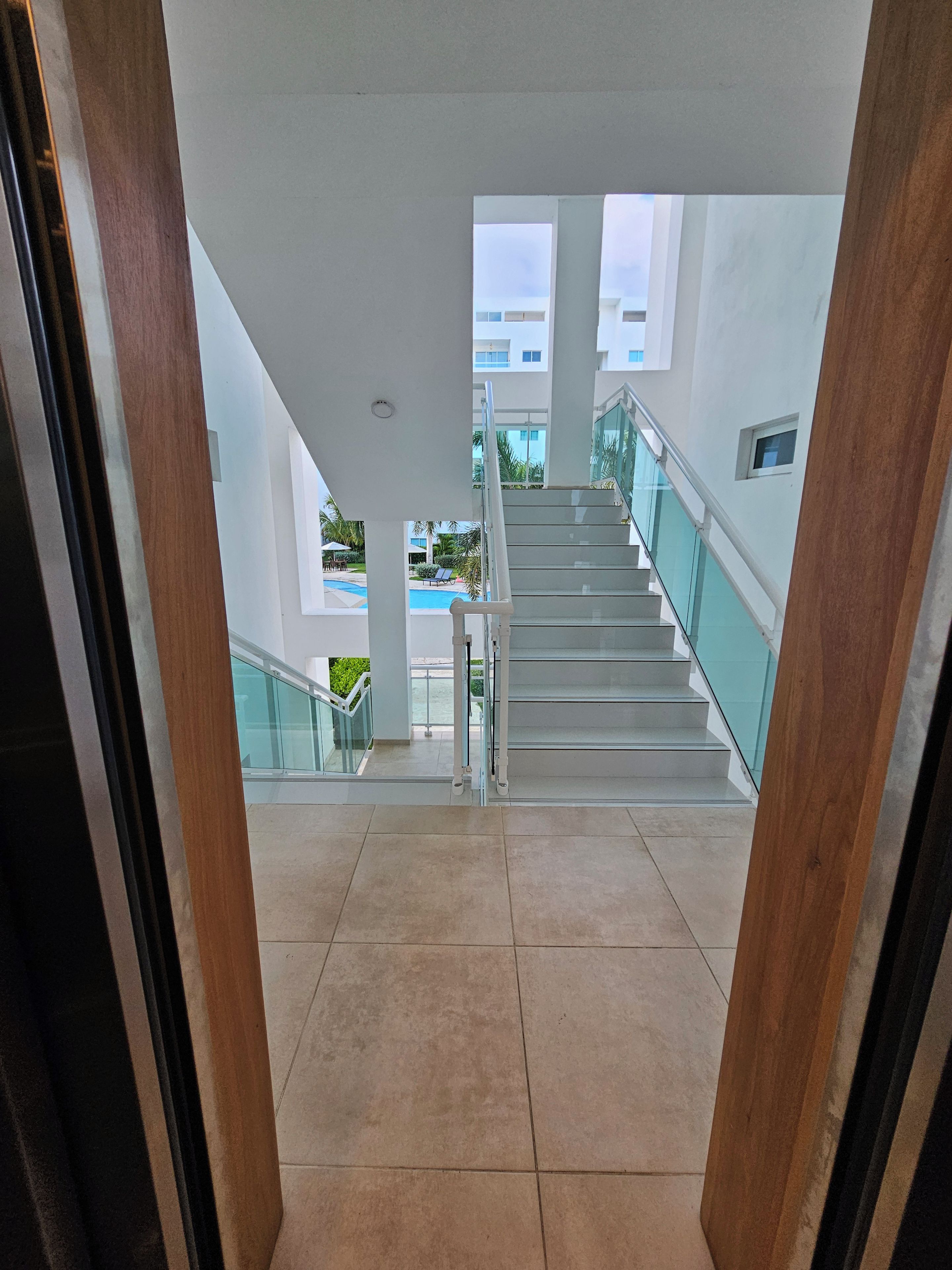 Interior moderno de hotel con una escalera que lleva a una zona de piscina.