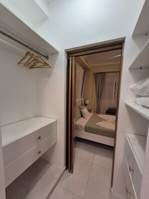 Quarto com cama, guarda-roupa e espelho.