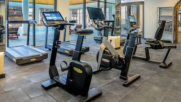 A gym with various exercise equipment including treadmills, stationary bikes, and elliptical machines.