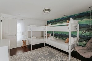 A room with two bunk beds, a hanging chair, a patterned rug, and a wall mural. - Farmhouse Central to Nelson 151 + Walk to Brewery! (Afton)