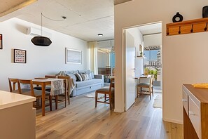 Ein modernes Interieur mit Essbereich, einer Couch und Blick auf die Stadt.