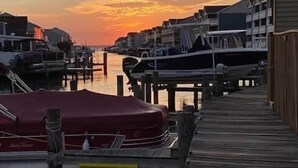 A waterfront dock with boats, wooden walkways, and buildings in the background. - Indoor Outdoor Pools, Balcony and Fenced Yard, Walk to Beach (Ocean City)