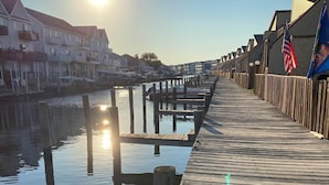 A wooden pier extending into calm water, with a clear sky and the sun low on the horizon. - Indoor Outdoor Pools, Balcony and Fenced Yard, Walk to Beach (Ocean City)