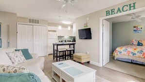 A compact living space with a kitchenette, a dining area, a bedroom, and a ceiling fan. - Indoor Outdoor Pools, Balcony and Fenced Yard, Walk to Beach (Ocean City)