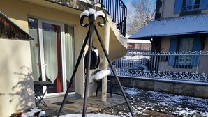 Een stenen waterput met metalen frame, omgeven door sneeuw op een verhard gebied.