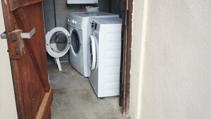 Ein Waschraum mit Waschmaschine, Trockner und Warmwasserbereiter.