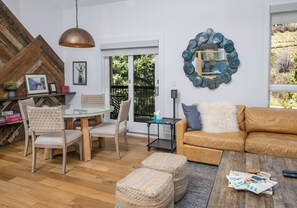 A living room with a glass table, two chairs, a brown leather sofa, and a coffee table with magazines. - Modern townhome on the river and walk to Cascade Chairlift!! (Vail)