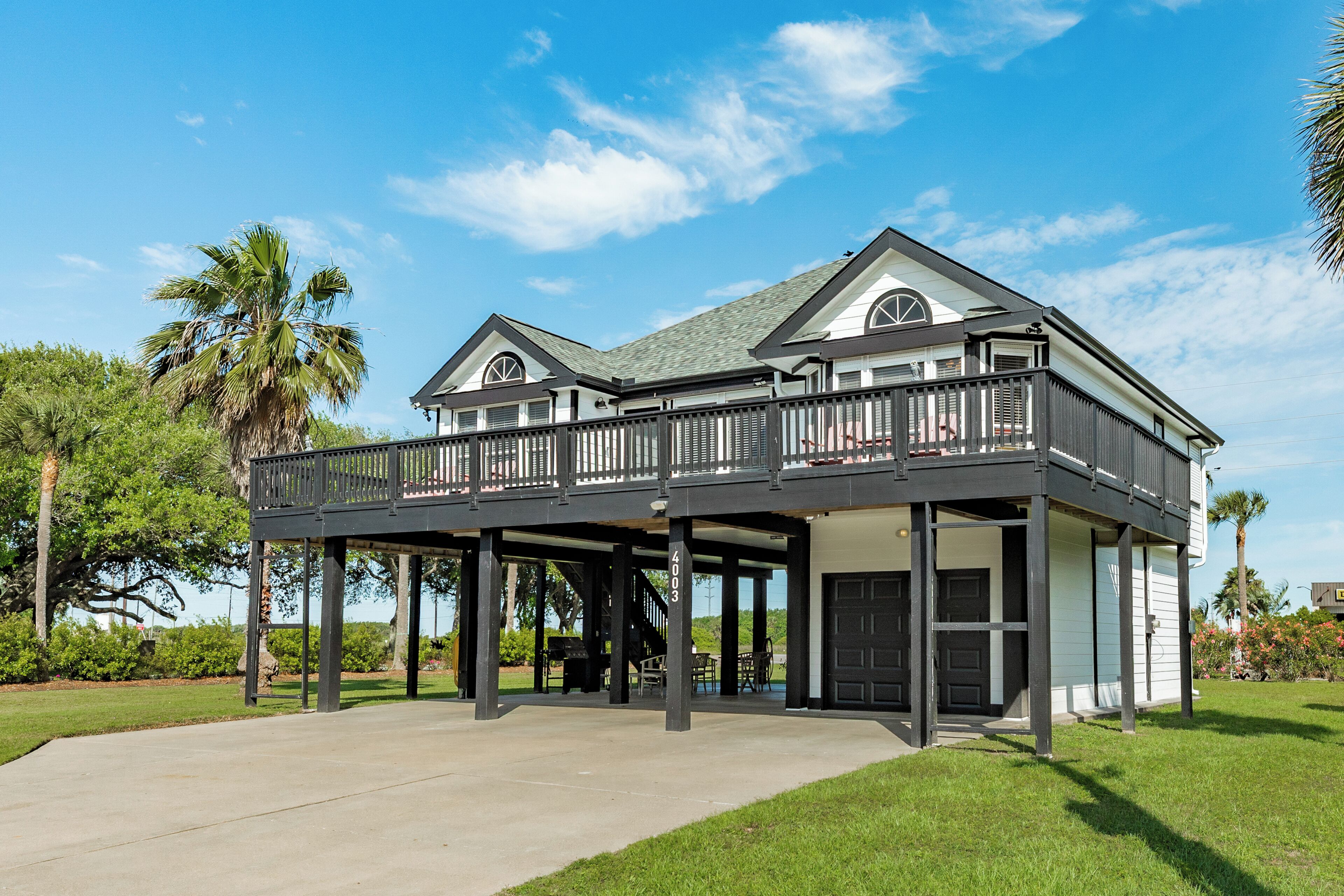 A two-story house with a balcony, a garage, and a well-maintained lawn.