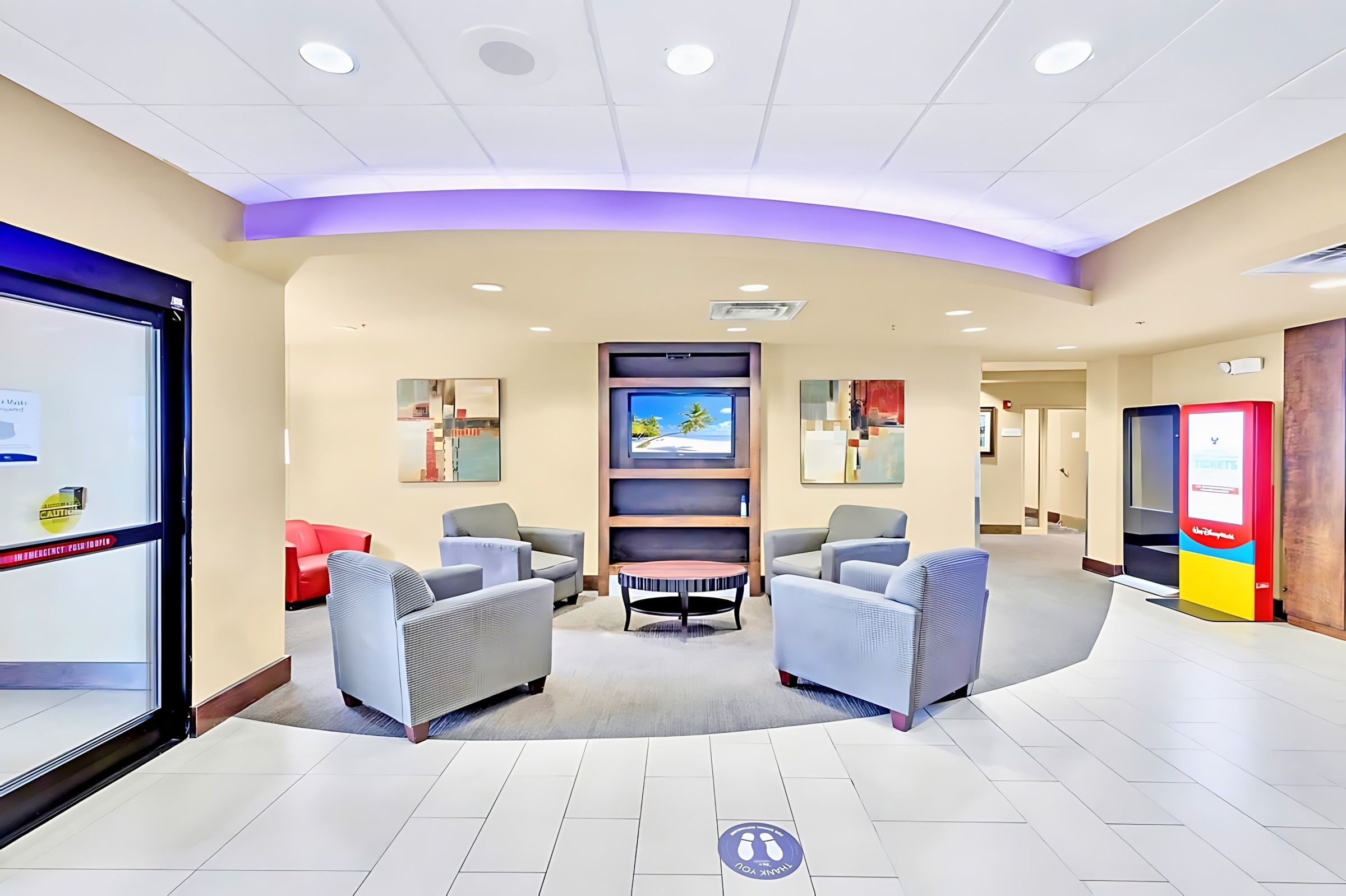 A lobby with seating, a television, and a vending machine.