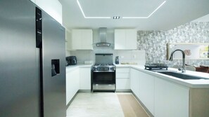 A modern kitchen with white cabinets, a stainless steel range, and a built-in oven. - Luxury 2-bedroom 2-bathroom condo with jacuzzi and huge pool in  Punta Cana (Punta Cana)