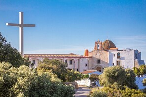A church with a prominent cross, a bell tower, and a dome.