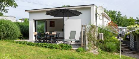A modern house with a patio, a dining area, and a covered outdoor space.