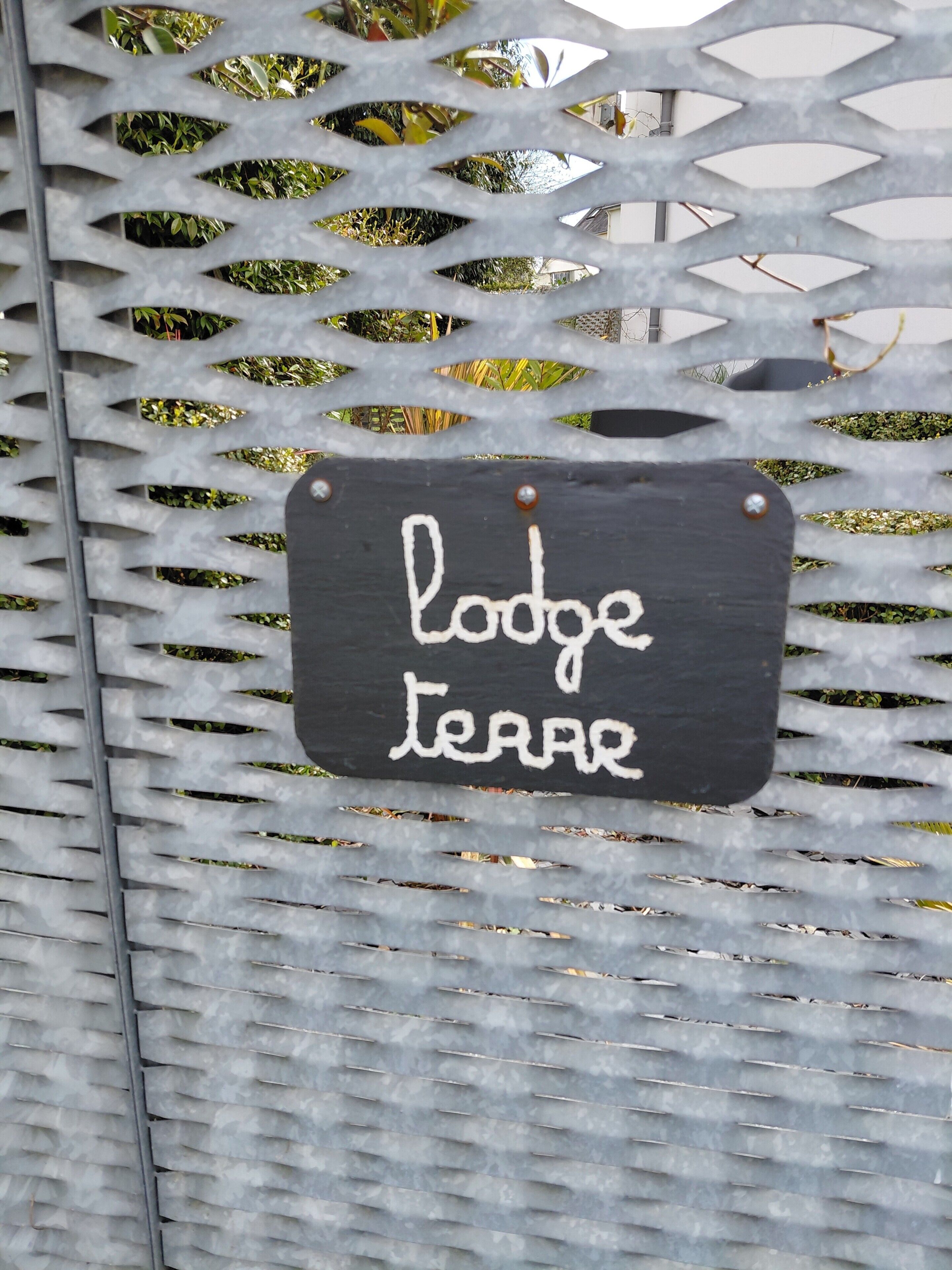 Une grille en métal sur laquelle est apposée une plaque indiquant : « Lodge Terrace ».