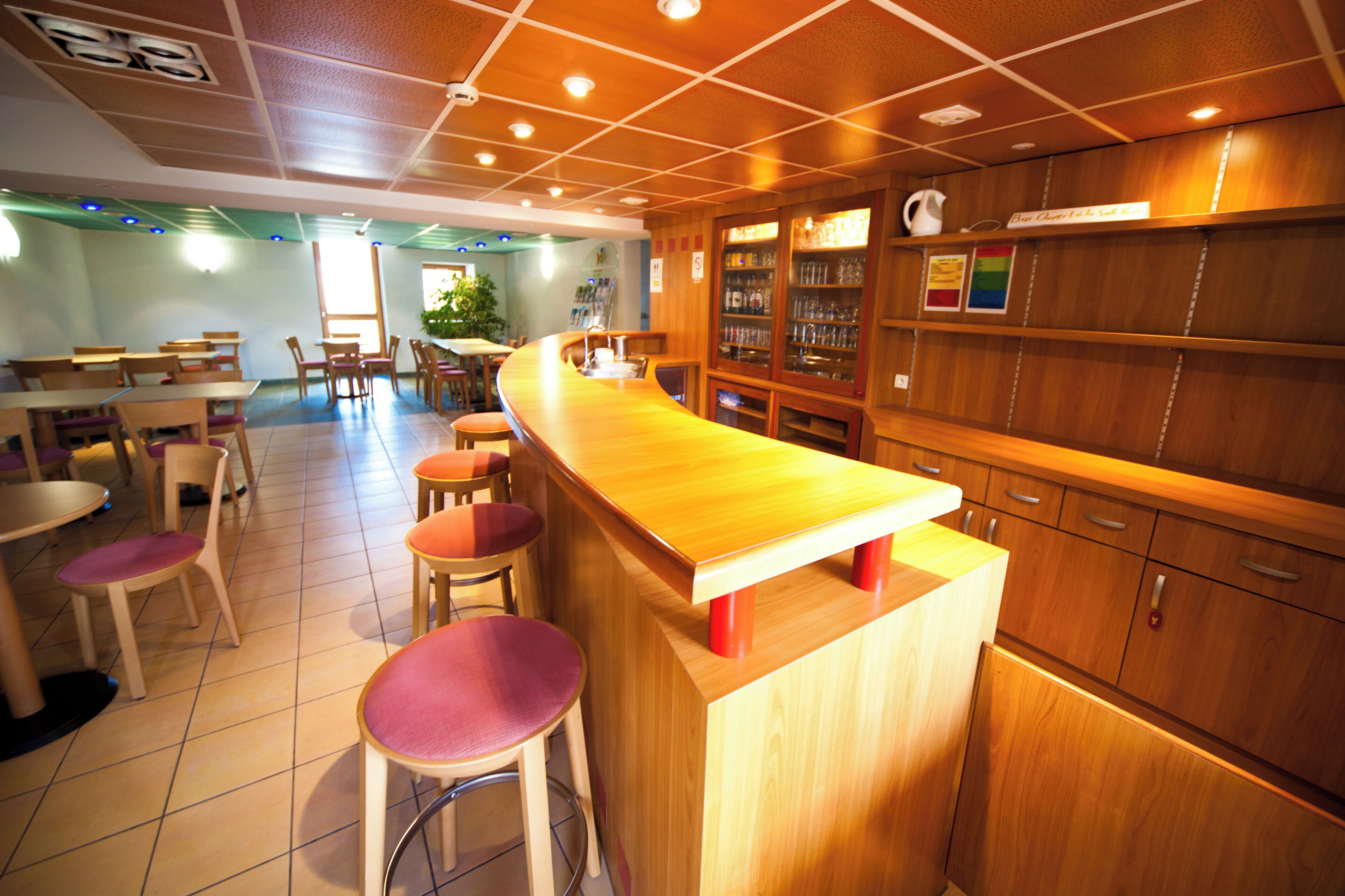Ein Restaurant mit einer Holztresore, verschiedenen Sitzbereichen und einem Fliesenboden.