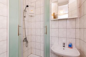 Ein Badezimmer mit Dusche, Waschbecken und Spiegel.