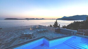 An infinity pool with a view of the sea and mountains at dusk. - 2-bedrooms apartment with AC (Dubrovnik)