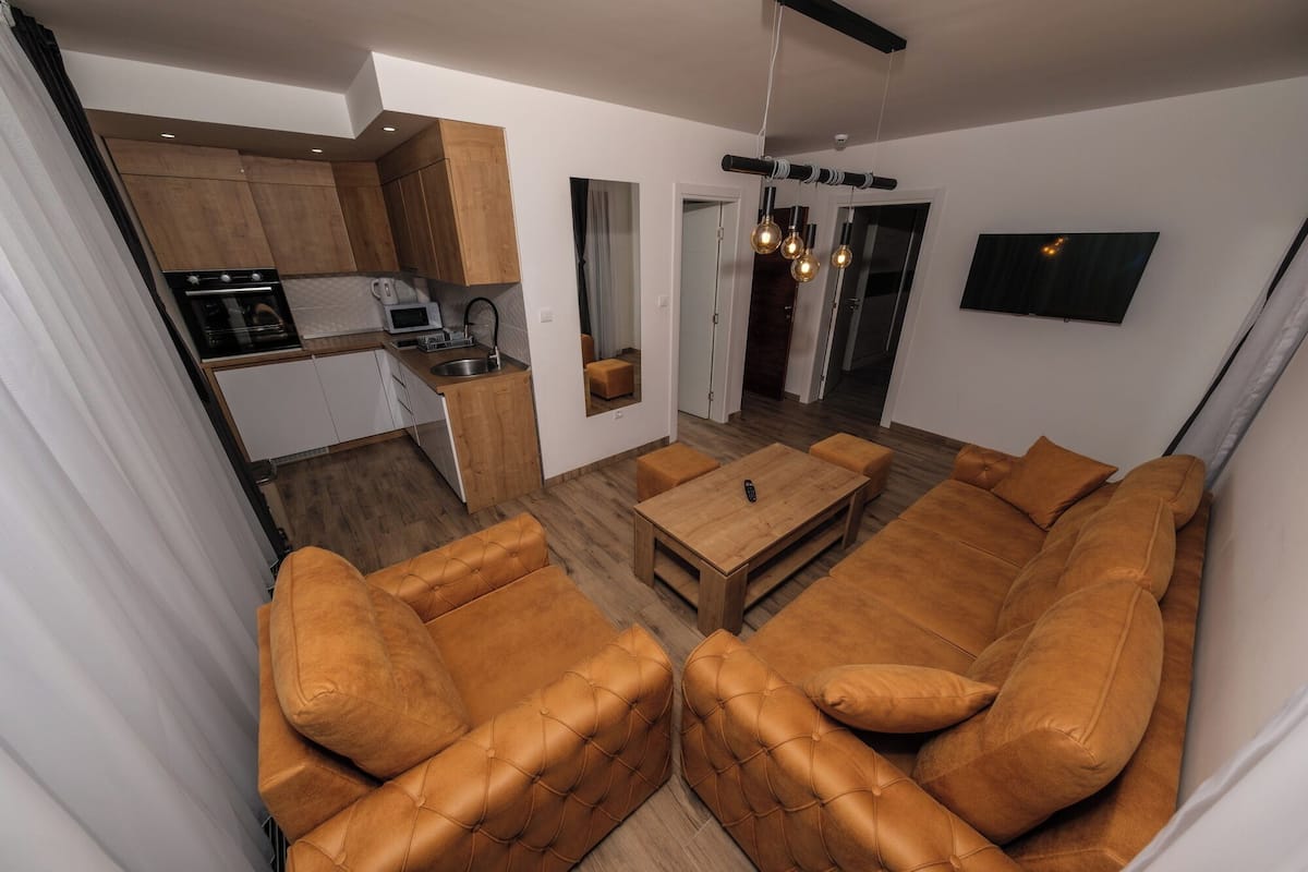 A modern living room with a sofa set and a dining table.