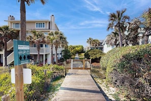 A wooden pathway leading to a building with a sign instructing to clean up after your dog. - Lagoon-View Villa Steps from the Beach (Isle of Palms)