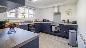 Una cucina moderna con lavatrice integrata, fornello e un'ampia finestra.