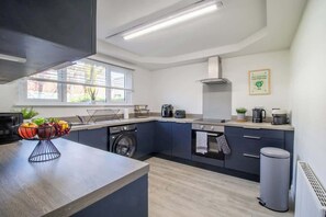 Eine moderne Küche mit eingebauter Waschmaschine, einem Herd und einem großen Fenster.