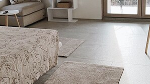 A bedroom with a bed, a TV, a sofa, a small table, and a balcony with a view. - Panoramic house 360° | 150sqm | 5 min from Lake Maggiore | Street parking (Cossogno)