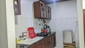 Une cuisine équipée d’un évier, d’une cuisinière, de placards et d’un réfrigérateur.