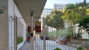 A paved walkway with a metal gate, a street lamp, and a building with a sign. - Studio 5 minutes from Copacabana and Ipanema beaches (Rio de Janeiro)