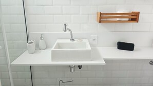 A bathroom with a white sink, a mirror, a towel rack, and a soap dispenser. - Studio 5 minutes from Copacabana and Ipanema beaches (Rio de Janeiro)