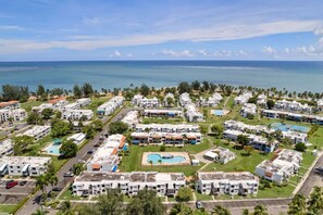 A resort with multiple buildings, a swimming pool, and a view of the ocean. - Luxe Yunque Retreat | Pool & Beach Access (Río Grande)