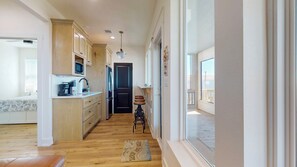 A kitchen with wooden cabinets, a microwave, and a refrigerator. - Ocean View II: 3 BR, 2 BA House in Gilchrist, Sleeps 8 (Gilchrist)