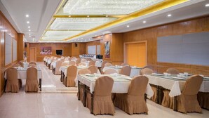 A banquet hall with rows of tables, chairs, and a large chandelier. - Vienna International Hotel - Dayong city (Zhangjiajie)