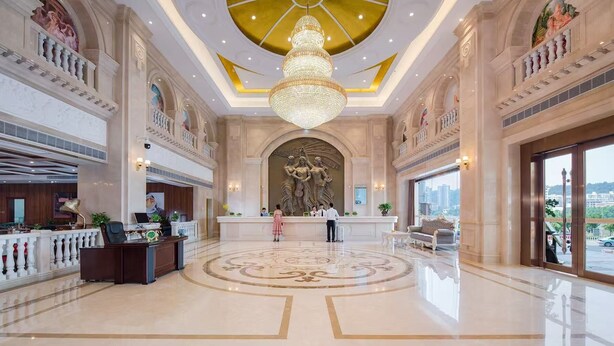 A grand lobby with a central chandelier, a reception desk, and a large mural. - Vienna International Hotel - Dayong city (Zhangjiajie)