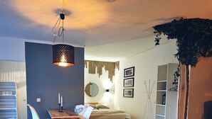 A modern interior with a wooden dining table, white chairs, a round mirror, and a hanging light fixture. - Holiday Home 'Cupedia' with Wi-Fi (Schwedeneck)
