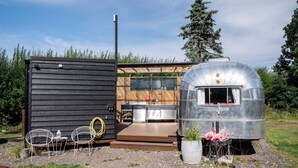 A modern RV with a kitchen area, a small deck, and a garden with a potted plant. - Sleeps 2 - Hot Tub - Pet Friendly - Peggysue (Skegness)