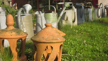 A collection of outdoor garden furniture, including pots and chairs, arranged on a grassy area.