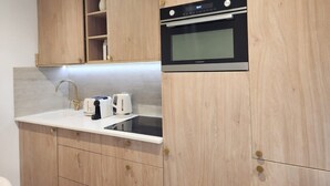 A kitchen with wooden cabinets, a built-in oven, a sink, and a toaster. - Beautiful Renovated Apartment With AC - Paris East (Paris)