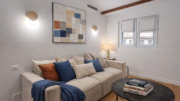 A living room with a sofa, a coffee table, a lamp, and a painting on the wall. - Beautiful Renovated Apartment With AC - Paris East (Paris)