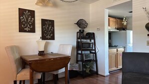 A dining area with a wooden table and chairs, a coffee machine, and decorative wall art. - Lovely Private Apartment with Pool in Walking Distance to Downtown Gatlinburg. (Gatlinburg)