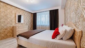 Un dormitorio con cama, cómoda, espejo y ventana con cortinas.