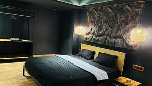 Een moderne slaapkamer met een bed, houten vloer, een wandplank en een decoratieve wandbekleding.