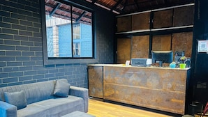 Een modern interieur met een bank, een bijzettafeltje en een toonbank met een gaasstructuur.