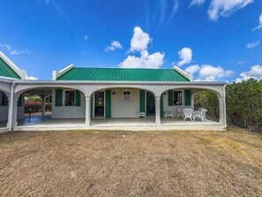 Un bâtiment à deux étages doté d’un toit végétalisé et d’un patio couvert avec des sièges extérieurs.