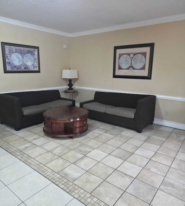 A living room with two sofas, a round coffee table, and two framed pictures on the walls.