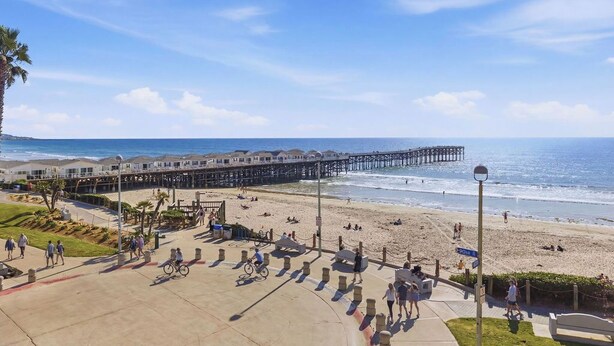 A beach with a pier, people walking, and a boardwalk. - Oceanfront Oasis in Pacific Beach  Walk to PB Pier  Pool Monthly Rental (San Diego)